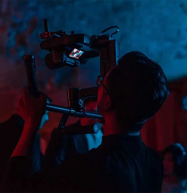 Man holding up camera on dark set